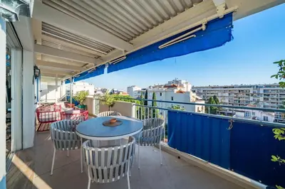 a balcony with a table and chairs and a view at COZYSTAY - Charmant 3 pièces en dernier étage in Cannes