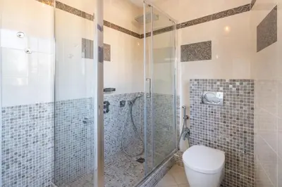 a bathroom with a toilet and a glass shower at COZYSTAY - Charmant 3 pièces en dernier étage in Cannes