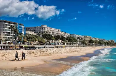 two people walking on the beach near the ocean at Cannes 1 bedroom apartment - 20LM3 in Cannes