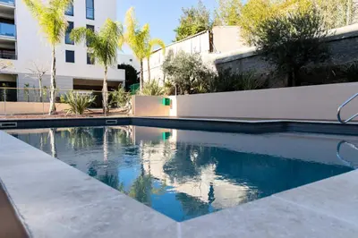 a swimming pool in front of a building at Résidence 3p Avec Jardin Et Piscine Au Coeur Du Palm Beach - 3P avec jardin et piscine au coeur du Palm Beach MAE-1643 in Cannes