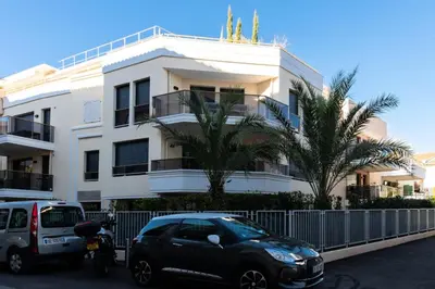 a black car parked in front of a white building at Résidence 3p Avec Jardin Et Piscine Au Coeur Du Palm Beach - 3P avec jardin et piscine au coeur du Palm Beach MAE-1643 in Cannes