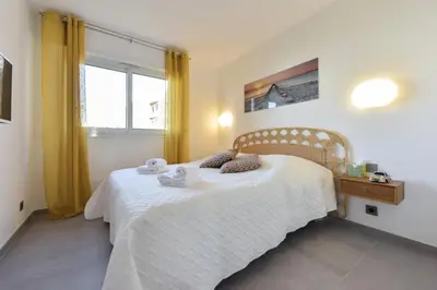 a bedroom with a bed with a white blanket and a window at Résidence 4 Pièces Refait à Neuf, 3 Min De La Croisette - 4 pièces refait à neuf, 3 min de la Croisette MAE-1893 in Cannes