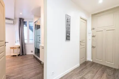 a hallway with white walls and wooden floors and a door at Résidence 2p Centre-ville Cannes Plages à Pied - 2P Centre-Ville Cannes Plages à Pied MAE-3043 in Cannes