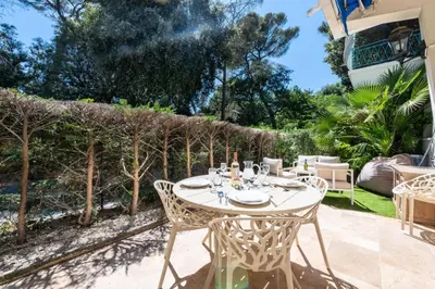 a patio with a table and chairs and trees at Résidence 2p Rez-de-jardin Au Calme – Cadre Paisible - 2P Rez-de-jardin au calme – Cadre Paisible MAE-3313 in Cannes