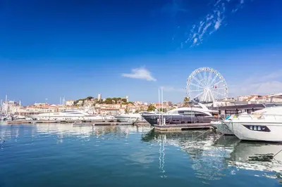 a group of boats docked in a harbor with a ferris wheel at Cannes Sea View - Port du Moure Rouge - Happy Rentals in Cannes
