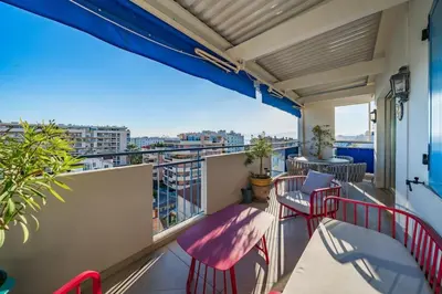 a balcony with red chairs and a view of a city at Top floor 3 Bedroom near the Croisette in Cannes
