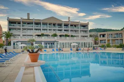 a large hotel with a swimming pool in front of it at Vue Mer - Piscine - Tennis - 2P avec Jardin - Cannes in Cannes