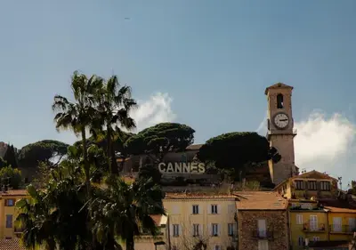 a clock tower on top of a city with a building at Charmant deux pièces au Suquet in Cannes