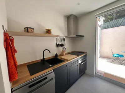 a small kitchen with a sink and a window at Elegant 3-BR Cannes Garden Condo - 5 Min Walk to Beach - behind Martinez in Cannes