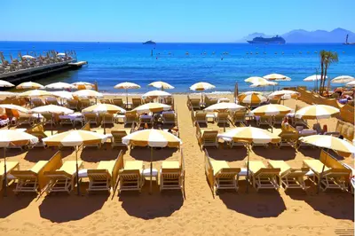 a bunch of chairs and umbrellas on a beach at Le Suquet Apartment - Cannes Old Town - Happy Rentals in Cannes