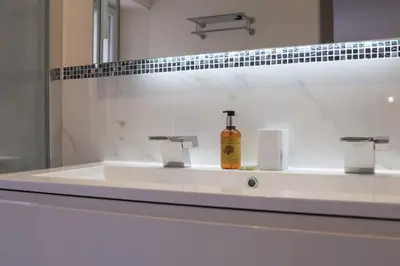 a bathroom sink with a bottle of soap on it at SUITE DE LUXE VERVEINE 4P in Cannes