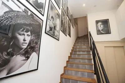 a hallway with pictures on the wall and stairs at SUITE DE LUXE MANDARINE 4P in Cannes