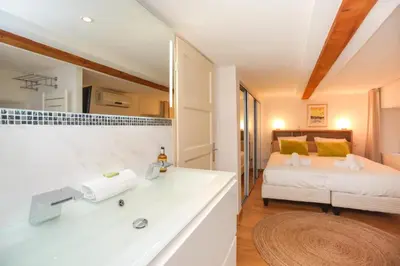 a bathroom with a sink and a bed in a room at SUITE DE LUXE MIMOSA 6P in Cannes