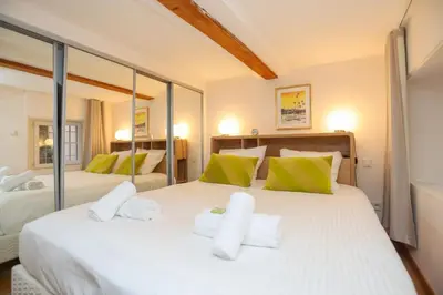 a bedroom with a large white bed with green pillows at SUITE DE LUXE MIMOSA 6P in Cannes