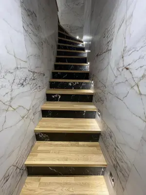 a staircase with marble walls and wooden steps at Suquet apartment cosy et charming in Cannes