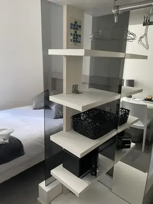 a bedroom with white shelves and a bed at Hôtel Anna Livia in Cannes