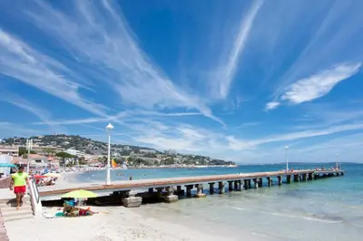 a pier on a beach with people on the beach at Apartment 2 bedrooms 2 bathrooms clear view in Palm beach area in Cannes