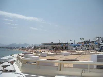 a beach with umbrellas and a group of boats at Charlie Chaplin 2 pièces 3 étoiles calme plein centre de Cannes, 5mn des plages et Palais in Cannes