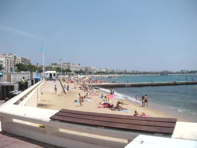 a group of people on a beach near a pier at Voyage 2 pièces 3 étoiles calme plein centre à 5mn des plages et du Palais in Cannes