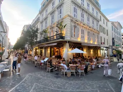 a group of people sitting at tables outside a building at Fabulous Central 1BR - Prime Location - Walk to Croisette & Palais - By Totolulu Cannes Blue Corner in Cannes