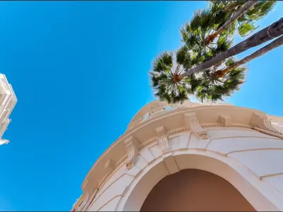 a building with a palm tree on top of it at Cannes Croisette Concorde Miramar in Cannes
