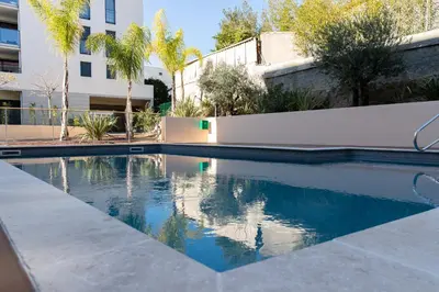 a swimming pool in front of a building at 2-Br with Garden and Pool in the Heart of Palm Beach in Cannes