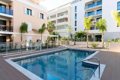 a swimming pool in front of a building at 2-Br with Garden and Pool in the Heart of Palm Beach in Cannes