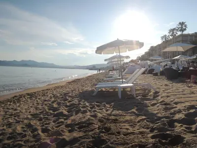a group of chairs and umbrellas on a beach at Prime Location Hyper Center Ideal for Couples & Families - Walk Everywhere - SMART by Totolulucannes in Cannes