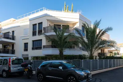 a car parked in front of a white building at 2-Br with Terrace and Pool in the Heart of Palm Beach in Cannes