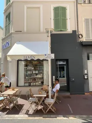a woman sitting at a table in front of a store at Scandinavian Urban 4 - 1BR apartment in Cannes center close to the beach and the Palais in Cannes