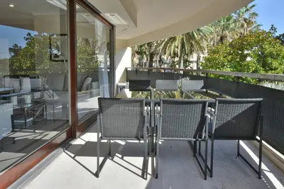 an outdoor patio with chairs and a table on a balcony at CANNES - 2-BR flat 15-min walk to the beaches in Cannes