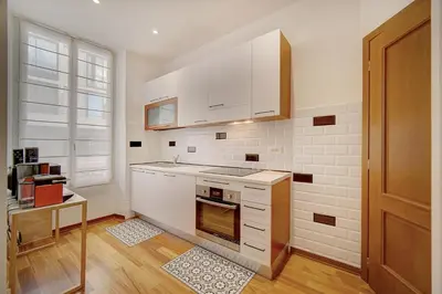 a kitchen with white cabinets and a stove top oven at Charmant 3 pièces rue d'Antibes in Cannes