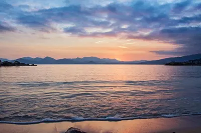 a sunset over a body of water with mountains at Brand new 2 BR Gambetta Fully Renovated 2021- 5 mns Palais by Olam Properties in Cannes