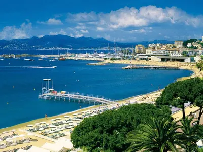 a beach with a pier and boats in the water at Apartment Villa Chalmette by Interhome in Cannes