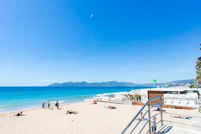 a beach with people laying on the sand and the ocean at C11 - 1 BDR Rue Meynadier 5min Palais Festivals & Sea - AC in Cannes