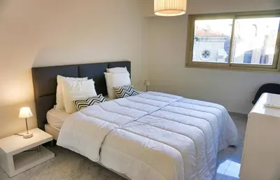 a bedroom with a large white bed and a window at LEM5D - Palmes d'Or Properties in Cannes