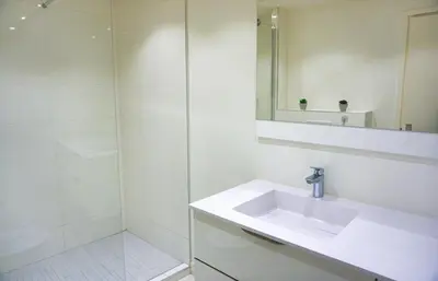 a white bathroom with a sink and a shower at LEM5D - Palmes d'Or Properties in Cannes