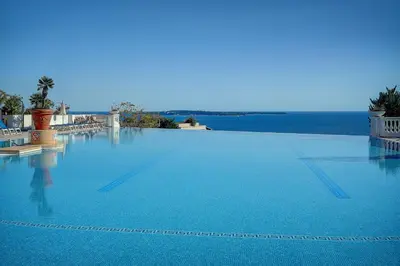 a large swimming pool with a view of the ocean at IMMOGROOM - 2 Rooms - Renovated - Pool - Parking - Air conditioning - in Cannes