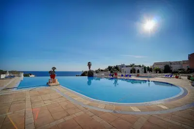 a large swimming pool with the ocean in the background at IMMOGROOM - 2 Rooms - Renovated - Pool - Parking - Air conditioning - in Cannes