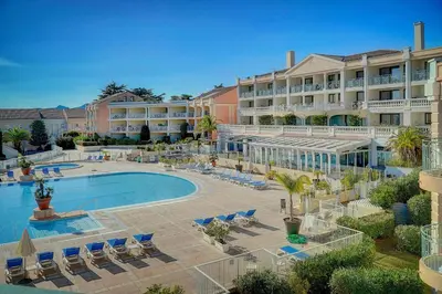 a resort with a pool and chairs and a hotel at IMMOGROOM - 2 Rooms sea view - Swimming pool - Terrace - Parking - AC in Cannes