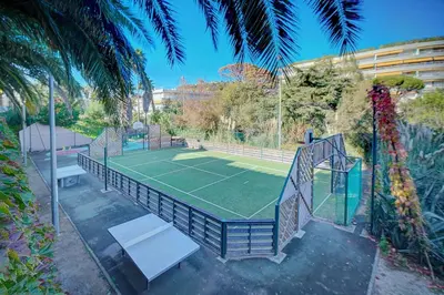 a tennis court with a net and a tennis at IMMOGROOM - 2 Rooms sea view - Renovated - Pool - Terrace - Parking - AC in Cannes