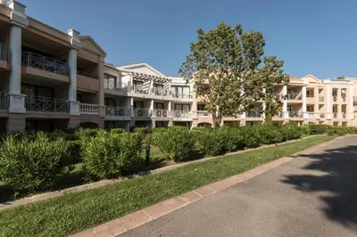 an apartment building with bushes in front of a street at Résidence Cannes Villa Francia - maeva Home - Appartement 3 Pièces 6 Personnes - Confort MAE-7944 in Cannes