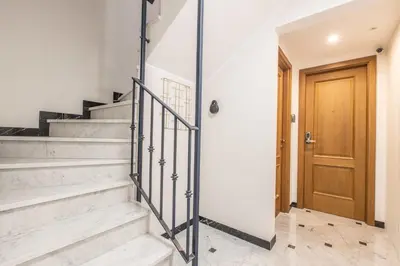 a staircase in a house with a wooden door at LB Vacation Rentals I Large Superieure Room with Balcony I Casa d'Azur in Cannes