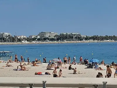 a group of people sitting on a beach at FORVILLE APARTMENT Cannes in Cannes