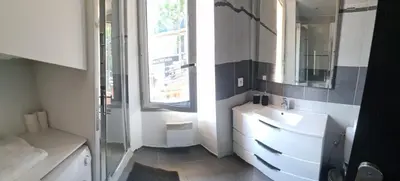 a bathroom with a sink and a mirror and a window at FORVILLE APARTMENT Cannes in Cannes