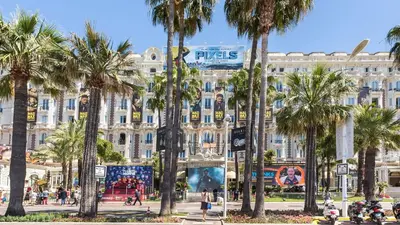a large building with palm trees in front of it at Bronze in Cannes