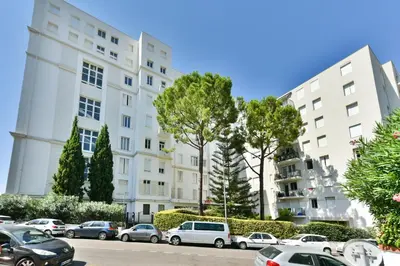 a row of cars parked in a parking lot in front of buildings at Cosy flat with parking - Basse Californie - Cannes in Cannes