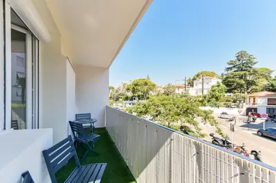 a balcony with two chairs and a view of a street at Cosy flat with parking - Basse Californie - Cannes in Cannes