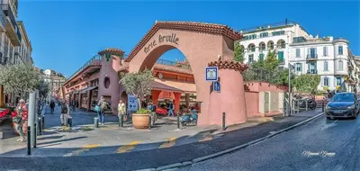 a building with an arch on a city street at Stunning 1 BR 3 pers Résidence Cannes Suquet Vieux Port Croisette 1 mn by Olam Properties in Cannes