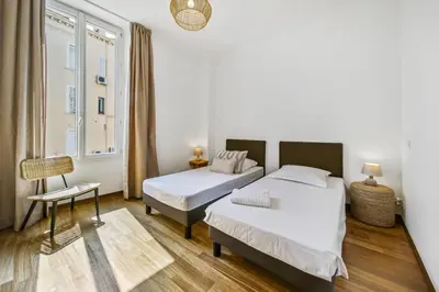 a bedroom with two beds and a window at REF 1320 - Cannes Center - Apartment for rent in Cannes